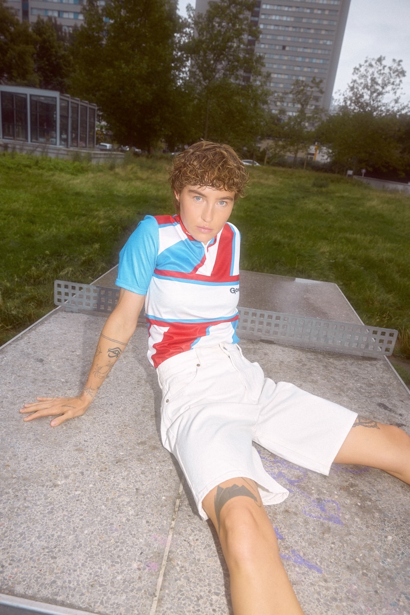 250805_GONSO_100_LOOK_01_124_Final_ polohemd, kurze_hose, Tattoos, casuales_outfit, urbaner_park