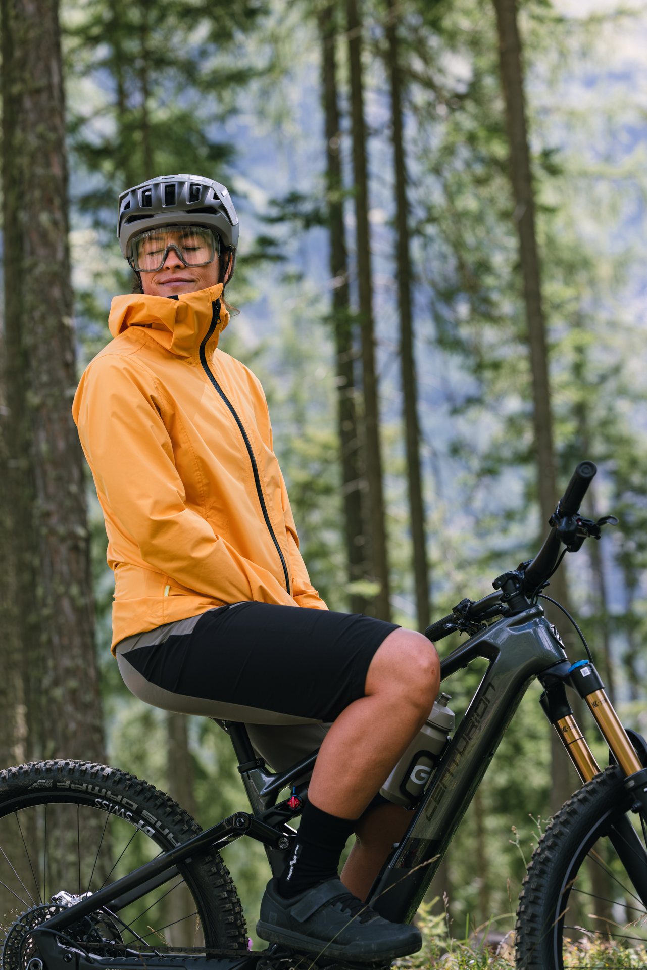 Mountain bike, Orange jacket, Fahrradhelm, Radsport-Shorts, Profiltiefe-Laufreifen